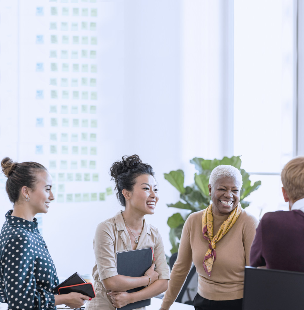Raznolika ekipa v pisarniških prostorih razpravlja o poslovnih idejah.